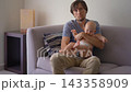 Exhausted father holding six-month-old son on couch and looking at camera. Concept of parental exhaustion. 143358909