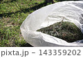 A garbage bag filled with weeds collected from weeding the garden. After outdoor work. 143359202