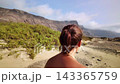 Woman walking alone on a sandy volcanic trail in Lanzarote Woman walking alone on a sandy volcanic trail in Lanzarote 143365759
