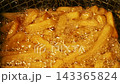 Close-up slow motion fried crispy potato wedges deep frying in oil. French fries 143365824