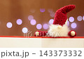 A close-up of a Tomte doll (a Nordic fairy) against a sparkling Christmas illumination background. 143373332