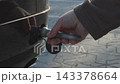 Mechanic installing a towing eye hook on a black car 143378664