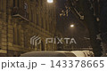 Heavy snow falling at night on a quiet city street in ukraine during winter 143378665
