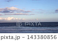 Ocean waves roll toward calm shoreline beneath wide blue sky. Gentle surf breaks in parallel lines, offering coastal view relevant to shoreline erosion and changing marine environments. 143380856