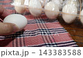 One white egg from a Silkie chicken. On a checkered mat. 143383588