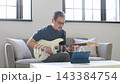 リビングでギターを弾く中高年男性 143384754