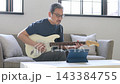 リビングでギターを弾く中高年男性 143384755