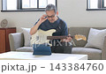 リビングでギターを弾く中高年男性 143384760