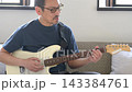 リビングでギターを弾く中高年男性 143384761