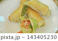 Baked puff pastry rolls with green pea filling served with vegetables 143405230