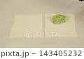 Green pea and almond filling placed on squares of puff pastry 143405232