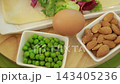 Fresh ingredients for puff pastry rolls: green peas, almonds and egg 143405236