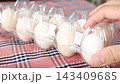 White Silkie chicken eggs in a pack. Checkered fabric background. 143409685