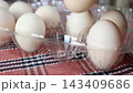 White Silkie chicken eggs in a pack. Checkered fabric background. 143409686