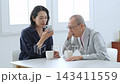 スマートフォンの説明を受ける難聴の高齢者 143411559