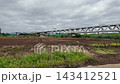 The Okuma River Truss Bridge of the Metropolitan Expressway Yokohama North Line, visible beyond the fields - Yokohama City, Kanagawa Prefecture, Japan 143412521
