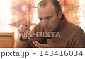 A man eating soup from a plate. 143416034