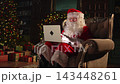 Merry Christmas. Santa Claus with laptop reading letters from children typing buying presents gifts online. Santa with computer on Christmas eve. Mail gifts of Santa Claus. Winter Holiday Celebrations 143448261