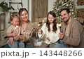 Merry Christmas Happy family mother father two children with glittering sparklers candle burns near Christmas tree. Parents kids celebrating Christmas enjoying winter holidays together. Family moments 143448266