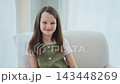 Happy girl at home. Smiling cute little brown haired Caucasian girl looking at camera. Portrait of happy female child at home. Smiling face of 10 year old girl looking at camera 143448269