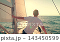 Yacht with sail gliding sea, cabin boy on deck gazing sun. Ships captain sailing ocean, raising hands. Sail towards your dream, adventure. Man sailing on yacht under white sail. Sea voyage free wind 143450599
