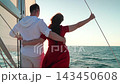 Yacht under sail glides through sea, man woman in love embrace on deck. Sail towards your dreams adventures. Captain Man woman travel on yacht under white sails. Sea voyage with free wind. Romance sea 143450608