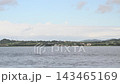 【船上からの風景】白い灯台がある防波堤と曇り空の港町の街並み（到着・出港） 143465169