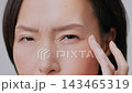Closeup Shot Of Middle Aged Japanese Woman Touching Eye Wrinkles Looking At Camera Having Nystagmus Problem Posing On Gray Studio Background. Facial Skincare For Aging Skin. Cropped 143465319