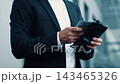 Focused Male, Middle Aged, Caucasian, Holding Dollar Bills While Standing In Business Attire At Urban Office Setting. Reflecting Financial Planning And Management Concept. 143465326