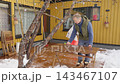 Happy winter lifestyle moment as a couple clears fresh snow from a cozy home patio. Cold weather, soft daylight, teamwork and seasonal mood create a warm family atmosphere. 143467107