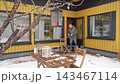 Happy winter lifestyle moment as a couple clears fresh snow from a cozy home patio. Cold weather, soft daylight, teamwork and seasonal mood create a warm family atmosphere. 143467114