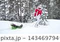 Grandmother pulling child on sled in snowy Finland, enjoying winter family lifestyle outdoors. Warm clothing, joy, love, and seasonal holiday atmosphere in bright daylight. 143469794