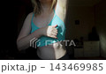 Woman performing breast self examination and checking armpit for lumps. Preventive healthcare routine for early cancer detection and personal wellness. 143469985
