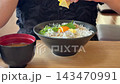 Squeeze lemon over a seafood bowl topped with fresh whitebait. 143470991
