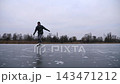 Guy skating on frozen river at cloudy day. Young man shod in figure skates sliding on ice surface outdoor. Sportsman training at lake in winter cold weather. Active leisure at wintertime. Slow motion 143471212