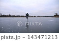 Young man shod in figure skates sliding on ice surface outdoor. Guy skating on frozen river at cloudy day. Sportsman enjoying sport and having active leisure at winter cold weather. Slow motion 143471213