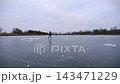 Young man shod in figure skates sliding on ice surface outdoor. Guy skating on frozen river at cloudy day. Sportsman having active leisure at lake in winter cold weather. Close up Slow motion 143471229