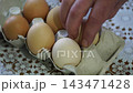 takes a few eggs from the package 143471428