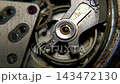 Extreme macro shot of vintage mechanical watch balance wheel and oscillating balance spring with ruby jewel bearings 143472130