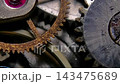 Extreme macro shot of vintage mechanical watch movement with rotating rusty gears and ruby jewel bearing 143475689