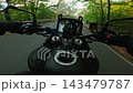 POV motorcycle ride on an asphalt road through an autumn forest at sunset, with golden foliage, warm evening light and motion blur creating a dynamic sense of speed and travel. 143479787