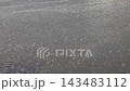 rain drops falling on wet asphalt with cars passing by 143483112
