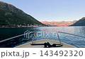 Motorboat navigating the waters of Kotor Bay with scenic Montenegrin mountains in the background 143492320