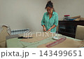 Talented woman working on dress patterns in her tailoring workshop 143499651