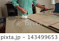 Talented tailor woman marking pattern on fabric with chalk at home workshop 143499653