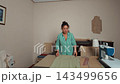 Talented tailor smoothing fabric and aligning patterns on a large wooden table in a cozy home sewing studio. 143499656