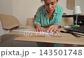 Talented woman sewing and creating patterns in her home workshop studio. 143501748