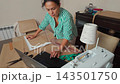 Talented woman sewing and creating patterns in her home workshop studio. 143501750