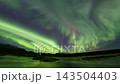 Full sky purple green aurora borealis reflecting in lake Thingvellir Iceland 143504403