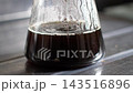 Freshly brewed coffee accumulating in a glass carafe; condensation forming on the inside; live-action 4K. 143516896